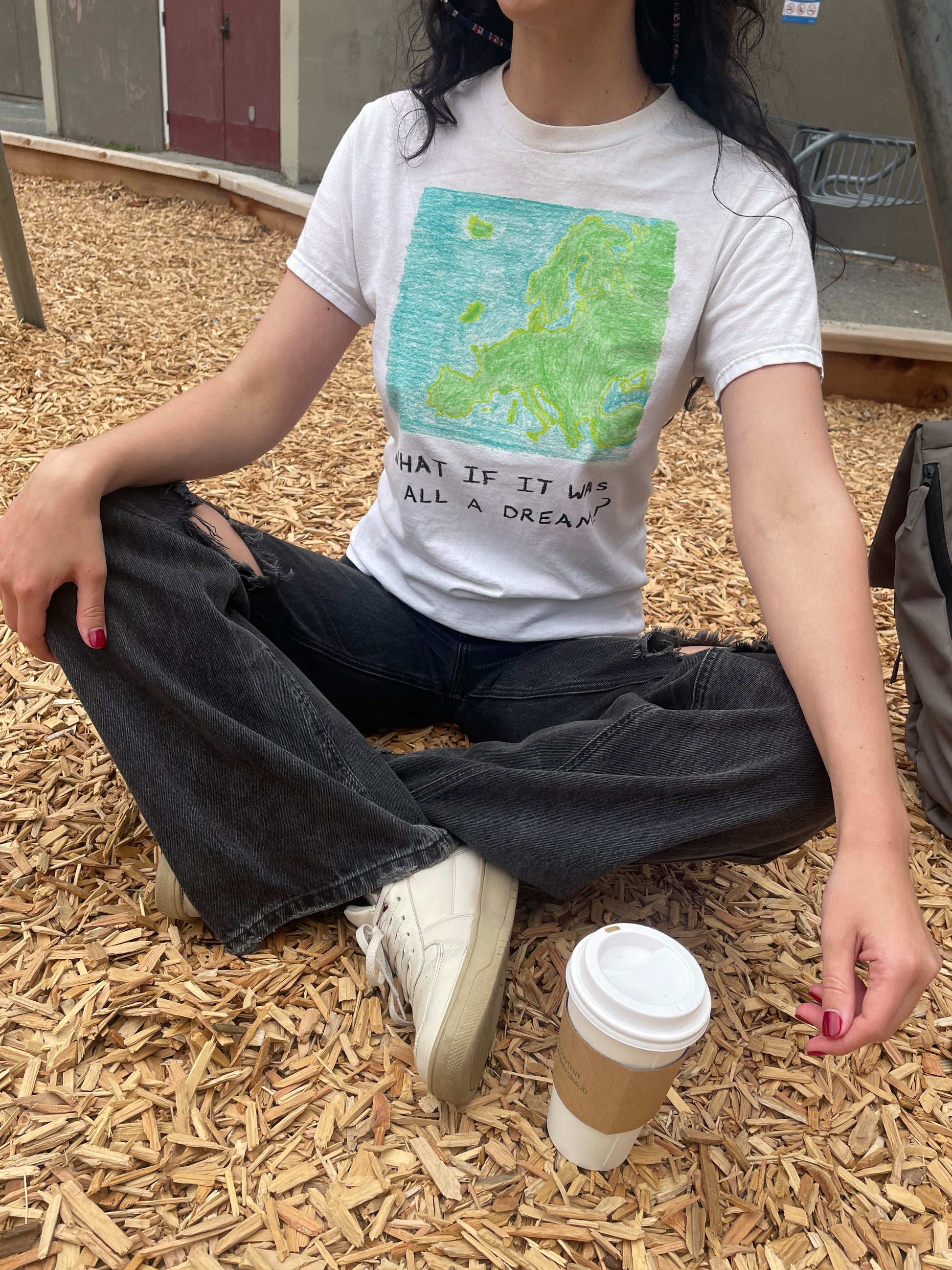 Fashionable adult woman wearing a trendy funny graphic t shirt made from cotton. The design is a funny graphic design that reads a humorous phrase what if it was all a dream featuring a map of Europe with the UK missing paying tribute to brexit and making a funny joke about that on a piece of clothing it would make a good gift 